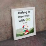 Wall art for kids featuring a happy cat in a Santa outfit holding a gift with the text Nothing is impossible with God. displayed on the wall in a white frame