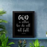 God Is Within Her, She Will Not Fall Psalm 46:5 Bible verse wall art in white text on a black background. displayed on the wall in a black frame