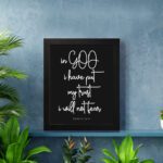 Christian wall art featuring Psalm 56:4 in bold white text on a black background. displayed on the wall in a black frame