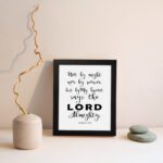 Not By Might Nor By Power Zechariah 4:6 Christian wall art with black text on a white background. displayed on the wall in a black frame