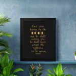 Cast Your Burden on the Lord Psalm 55:22 gold text on black background Christian wall art. Wall Art displayed on the wall in a black frame