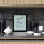 Cook Sing Dance kitchen wall art with hand-drawn fonts, colorful doodles, and a textured light blue background. displayed on the table