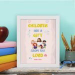 Christian wall art with happy children holding hands and Psalm 127:3 text 'Children are a gift from the Lord. displayed on the table in a white frame