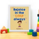 Rejoice in the Lord always, Philippians 4:4 Christian wall art with smiling child and bright colors. displayed on the table in a white frame