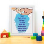 Wall art depicting two hands holding each other with the verse Let the little children come to me in blue text on a watercolor background. displayed on the table in a white frame