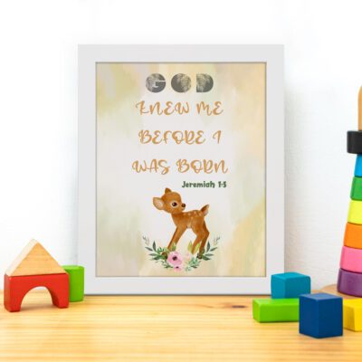 Artwork of a baby deer with flowers and the verse God knew me before I was born in warm colors. Perfect for children's decor. displayed on the table in a white frame