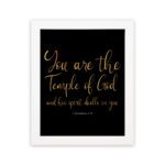 You Are The Temple Of God Bible Wall Art with gold text on a black background from 1 Corinthians 3:16. hung on the wall in a white frame