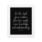 Proverbs 2:6 Christian wall art with white text on a black background – For the Lord gives wisdom design. hung on the wall in a white frame