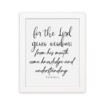 Proverbs 2:6 Christian wall art with black cursive text on a white background. For the Lord gives wisdom. hung on the wall in a white frame