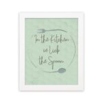 In This Kitchen We Lick The Spoon kitchen wall art with light green background and subtle kitchen utensil pattern in a casual handwritten font.displayed on the wall in a white frame in a white background