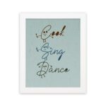 Cook Sing Dance kitchen wall art with hand-drawn fonts, colorful doodles, and a textured light blue background. displayed on the wall in a white frame in a white background