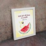 With God, All Things Are Possible Matthew 19:26 Bible Verse Wall Art featuring a bird and watermelon design for kids. displayed on the wall in a white frame