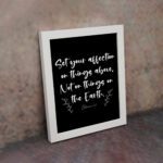 Set Your Affection on Things Above Colossians 3:2 Bible Verse Wall Art on white background with white text and leaf decorations. displayed on the wall in a black frame