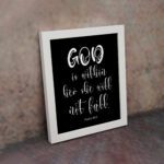 God Is Within Her, She Will Not Fall Psalm 46:5 Bible verse wall art in white text on a black background. displayed on the wall in a white frame