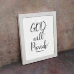 Infidu wall art with the text "GOD will provide" in black font on a white background, featuring the Bible verse Philippians 4:19. displayed on the wall in a white frame