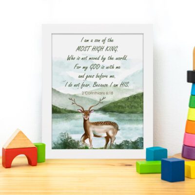 The lakeside scene with a deer and mountains features the verse I Am A Son Of The Most High King in calming colors. displayed on the table in a white frame