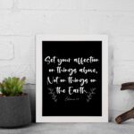 Set Your Affection on Things Above Colossians 3:2 Bible Verse Wall Art on white background with white text and leaf decorations. displayed on the wall in a black frame