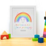 Cheerful rainbow wall art with the text Rainbows Are Your Promises in colorful letters, designed for kids' room decor. displayed on the table in a white frame