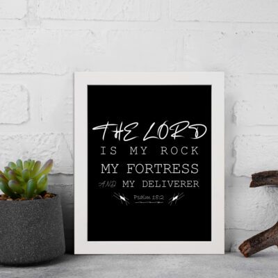 Bible wall art featuring Psalm 18:2 with the text The Lord is my rock, my fortress, and my deliverer in bold and cursive fonts. displayed on the wall in a white frame