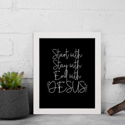 Christian wall art with the phrases Start With Jesus, Stay With Jesus, and End With Jesus in white text on a black background. displayed on the wall in a white frame