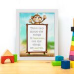 Wall art featuring a happy monkey holding a sign with the verse 'Think only about the things in heaven' from Colossians 3:2. displayed on the table in a white frame