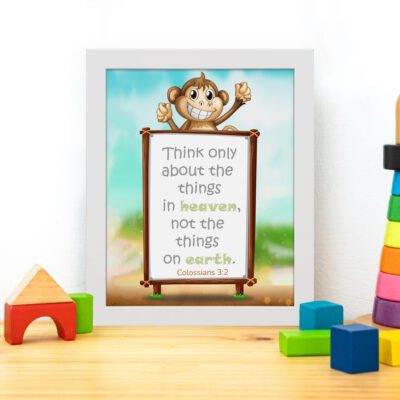 Wall art featuring a happy monkey holding a sign with the verse 'Think only about the things in heaven' from Colossians 3:2. displayed on the table in a white frame