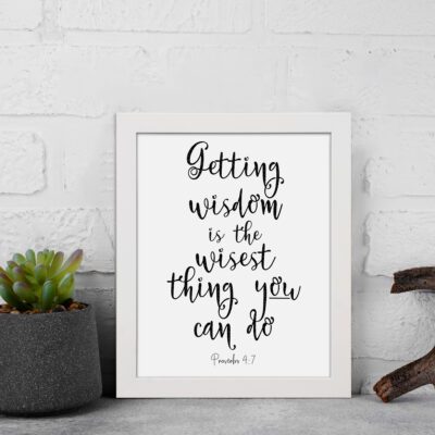 Wall art featuring the quote 'Getting wisdom is the wisest thing you can do' from Proverbs 4:7 on a white background. displayed on the wall in a white frame