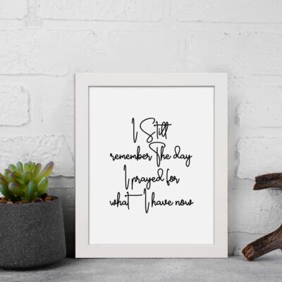 Black text on a white background featuring the quote I still remember the days I prayed for what I have now in elegant styles. displayed on the wall in a white frame