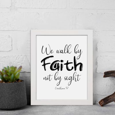 Christian wall art featuring the quote We walk by faith not by sight from Corinthians 5:7 in black text on a white background. displayed on the wall in a white frame