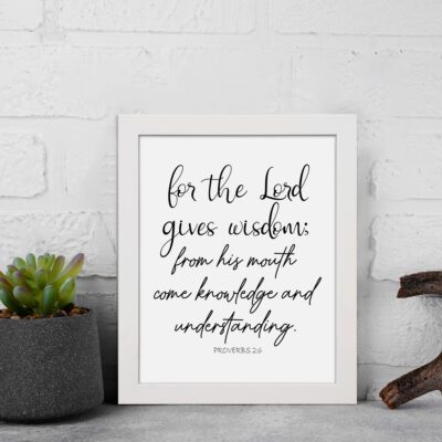 Proverbs 2:6 Christian wall art with black cursive text on a white background. For the Lord gives wisdom. displayed on the wall in a white frame