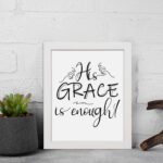 His Grace Is Enough Christian wall art in black cursive font on a white background emphasizing the word 'GRACE'. displayed on the wall in a white frame