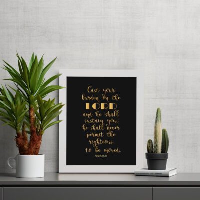 Cast Your Burden on the Lord Psalm 55:22 gold text on black background Christian wall art. Wall Art displayed on the table in a white frame