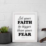 Let Your Faith Be Bigger Than Your Fear Hebrews 13:6 Christian Wall Art in black text on white background for home decor. displayed on the wall in a white frame