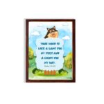 Cheerful dog character with Psalm 119:105 verse Your Word is like a lamp for my feet on a bright blue background. hung on the wall in a brown frame