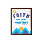 Wall art with the text Faith can move mountains from Matthew 17:20, featuring a sun rising over mountains. hung on the wall in a brown frame