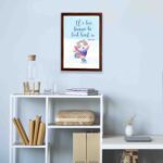 Wall art featuring a joyful bear in winter clothes holding a heart, with the verse We love because He first loved us from 1 John 4:19. displayed on the wall in a brown frame