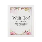 With God All Things Are Possible Matthew 19:26 Bible Verse Wall Art with black text and floral accents in pink and green on a white background. Wall Art hung on the wall in white frame