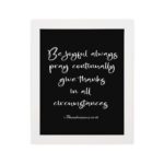 Bible verse wall art featuring 1 Thessalonians 5:16-18 in white cursive text on a solid black background, arranged clearly for easy reading. hung on the wall in a white frame