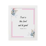 Infidu Bible wall art featuring Psalm 37:3 in black text with blue and pink floral accents and a soft pink border. Wall Art hung on the wall in a white frame