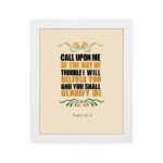 Psalm 50:15 Bible Wall Art with bold black, orange, and yellow text and simple floral embellishments on a cream background. Wall Art hung on the wall in white frame