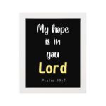 Psalm 39:7 Bible verse wall art with a black background, Lord in yellow. Christian home decor by Infidu. Wall Art hung on the wall in a white frame