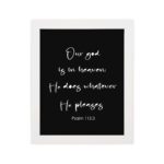 Bible verse wall art with Psalm 115:3 in white text on a black background. Simple and centered design for a bold, modern look. hung on the wall in a white frame