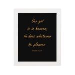 Bible verse wall art with Psalm 115:3 in gold text on a black background. Simple, elegant font centered for easy readability. hung on the wall in a white frame