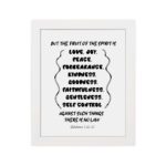 Galatians 5:22-23 Bible wall art featuring the fruits of the Spirit in a wavy text design on a white background. hung on the wall in a white frame