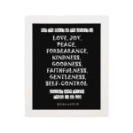 Galatians 5:22-23 Bible Verse Wall Art with White Text on Black Background hung on the wall in a white frame