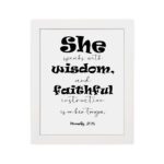 Proverbs 31:26 Bible wall art featuring bold and simple fonts on a white background, framed in black, highlighting the message of wisdom. hung on the wall in a white frame