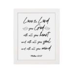 Matthew 22:37 Bible wall art with black text on a white background, featuring Love the Lord your God in cursive letters. hung on the wall in a white frame