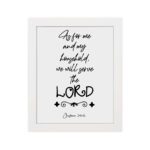 Joshua 24:15 Bible wall art with black text on a white background, framed in black, reading As for me and my household. hung on the wall in a white frame