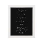 Joshua 24:15 Bible wall art with white cursive text on a black background, emphasizing LORD in a modern design. hung on the wall in a white frame