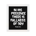 In His Presence There Is Fullness of Joy in bold white block letters with Psalm 16:11 on black background hung on the wall in a white frame - Christian wall art.